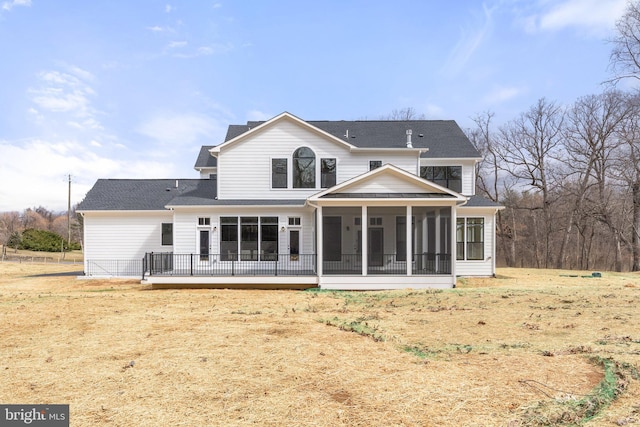 back of property with a sunroom