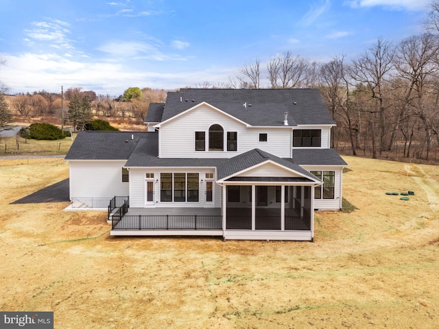 rear view of property with roof with shingles and a sunroom