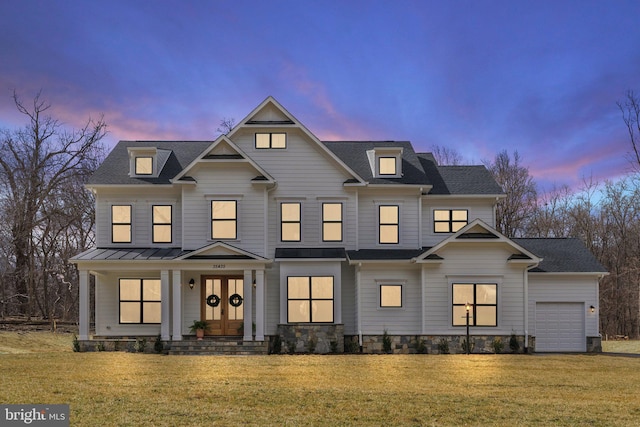 view of front of property with a garage, a lawn, metal roof, covered porch, and french doors