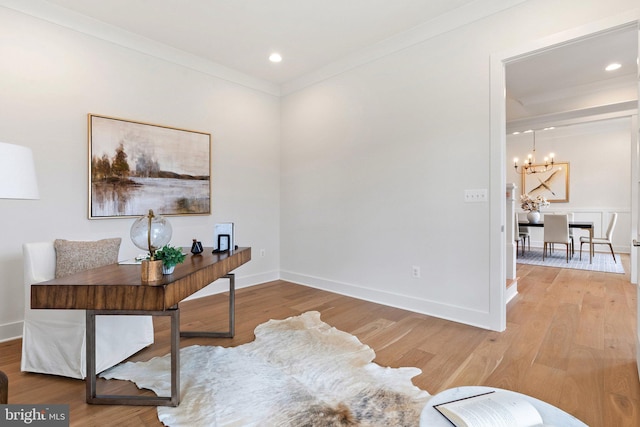 office area featuring light wood-type flooring, a notable chandelier, baseboards, and crown molding