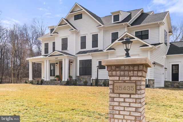 view of front of property with a garage, a front lawn, a porch, and a shingled roof