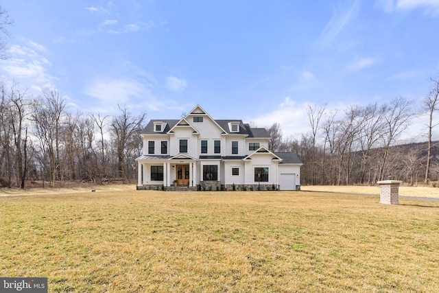 view of front of house featuring a porch, metal roof, an attached garage, a standing seam roof, and a front lawn