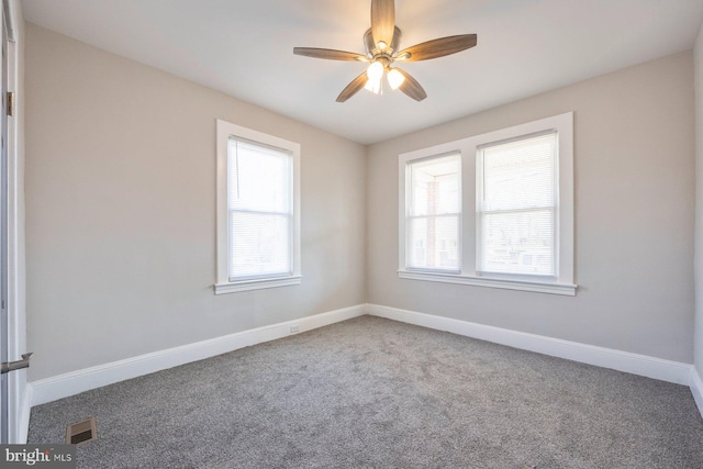 unfurnished room featuring plenty of natural light, a ceiling fan, and baseboards