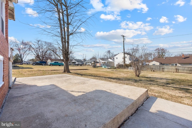 view of yard featuring a residential view, a patio, and fence