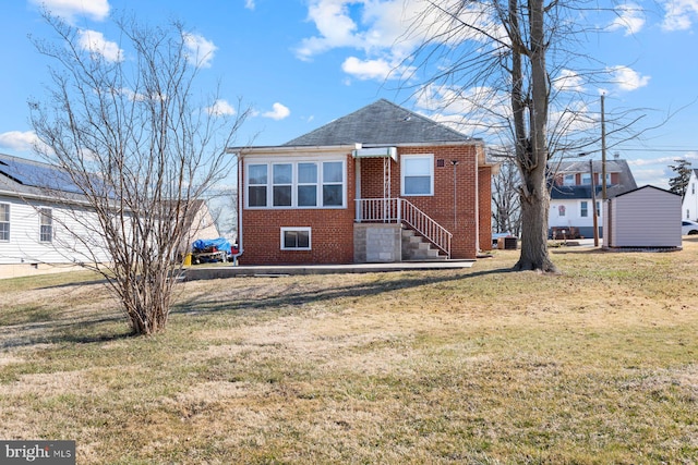 bungalow with brick siding and a front lawn