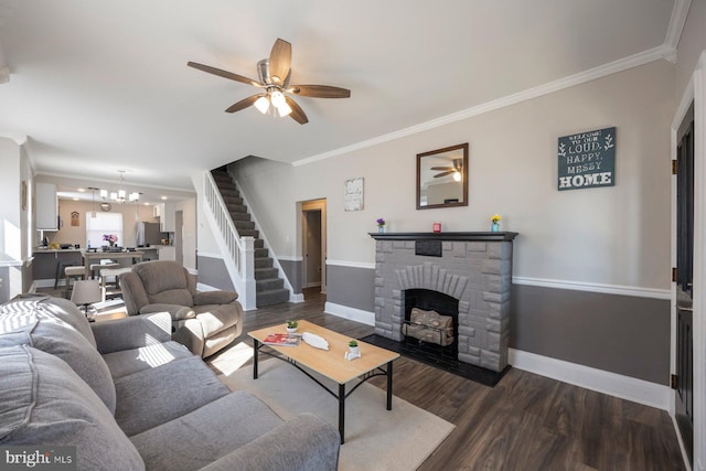 living area featuring dark wood-style floors, a fireplace with flush hearth, ceiling fan with notable chandelier, and crown molding