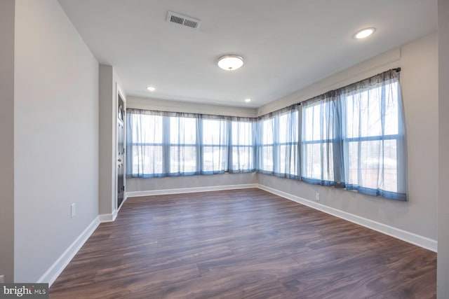 empty room featuring recessed lighting, visible vents, baseboards, and dark wood-type flooring