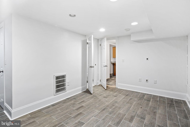 finished basement with baseboards, recessed lighting, visible vents, and wood tiled floor