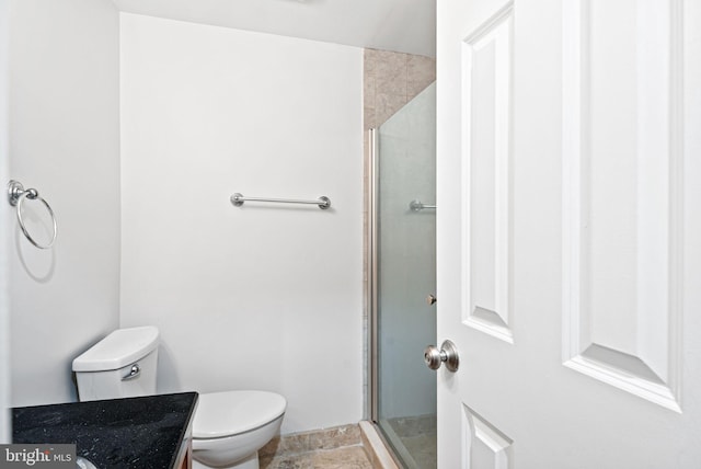 bathroom featuring toilet, a shower stall, and vanity