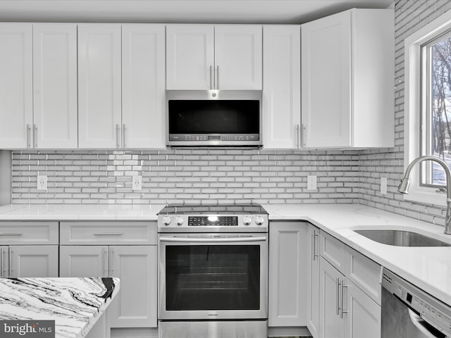 kitchen featuring stainless steel appliances, white cabinets, and a sink