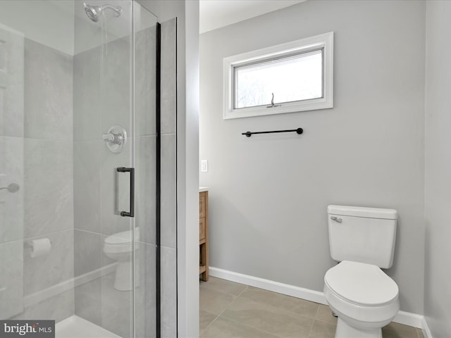 bathroom featuring toilet, a stall shower, baseboards, and vanity