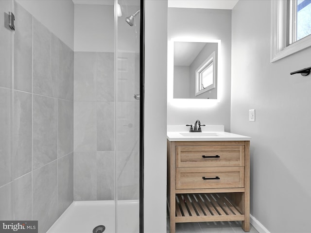 bathroom with a stall shower, vanity, and baseboards