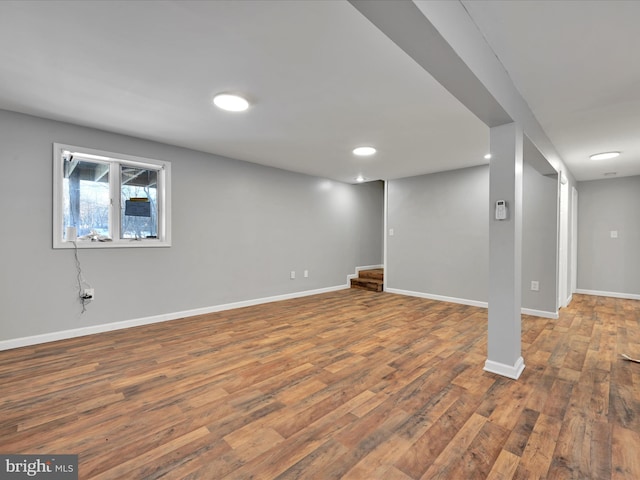 below grade area featuring stairs, recessed lighting, baseboards, and wood finished floors