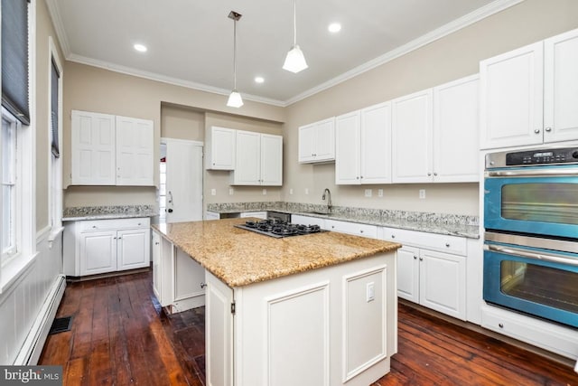 kitchen featuring stainless steel double oven, a baseboard heating unit, a kitchen island, gas stovetop, and white cabinetry