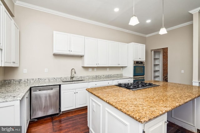 kitchen featuring a center island, crown molding, appliances with stainless steel finishes, white cabinetry, and a sink