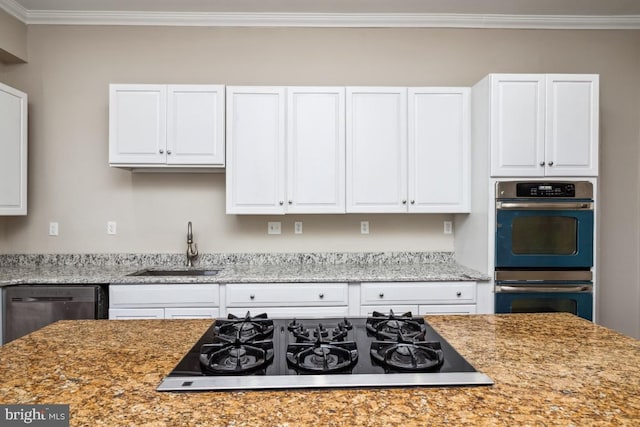 kitchen featuring light stone counters, a sink, white cabinets, ornamental molding, and appliances with stainless steel finishes