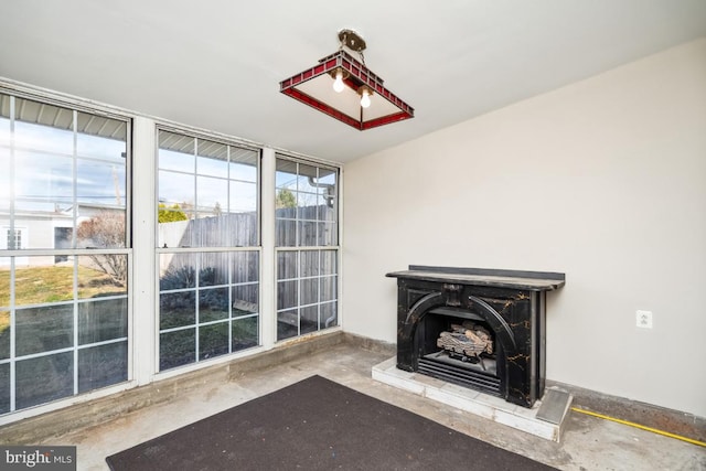 unfurnished living room with concrete flooring and a wealth of natural light