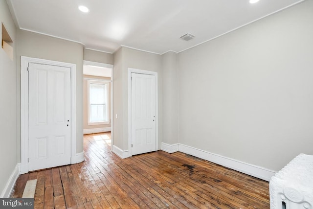 unfurnished bedroom with recessed lighting, wood-type flooring, visible vents, and baseboards