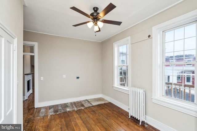 unfurnished room featuring a ceiling fan, radiator heating unit, hardwood / wood-style flooring, and baseboards