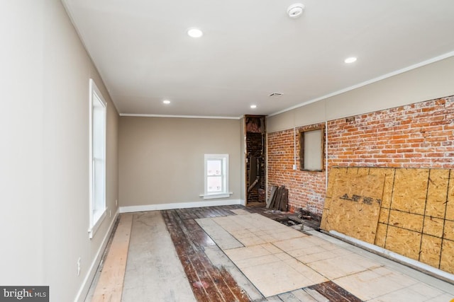 interior space featuring recessed lighting, brick wall, crown molding, and hardwood / wood-style floors