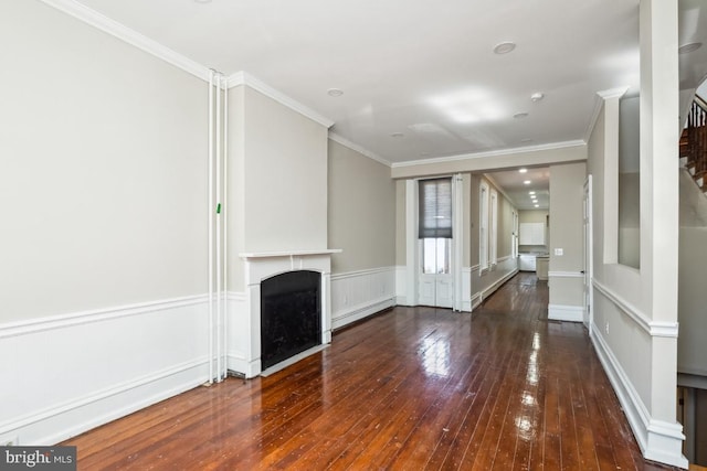 unfurnished living room with a wainscoted wall, crown molding, a fireplace, wood-type flooring, and a baseboard heating unit