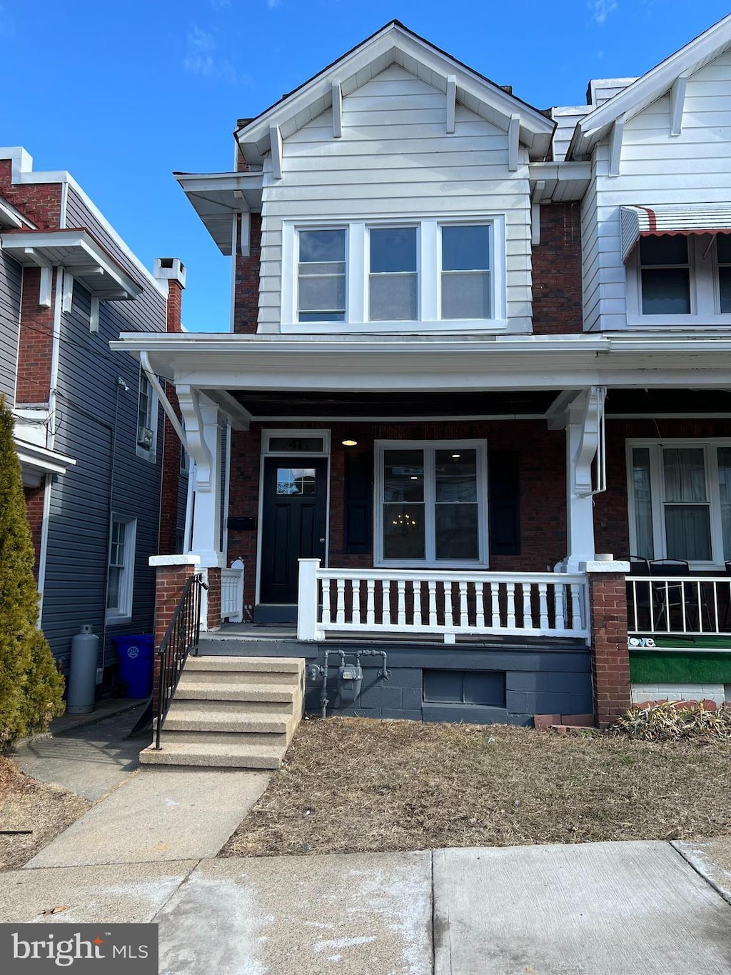 view of front of house with a porch and brick siding