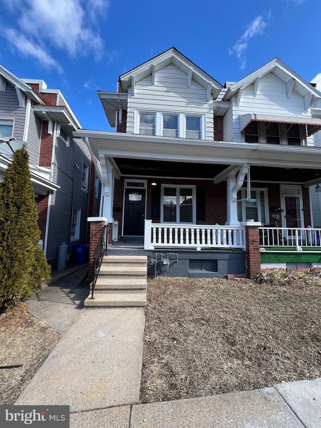 view of front of house featuring covered porch and brick siding