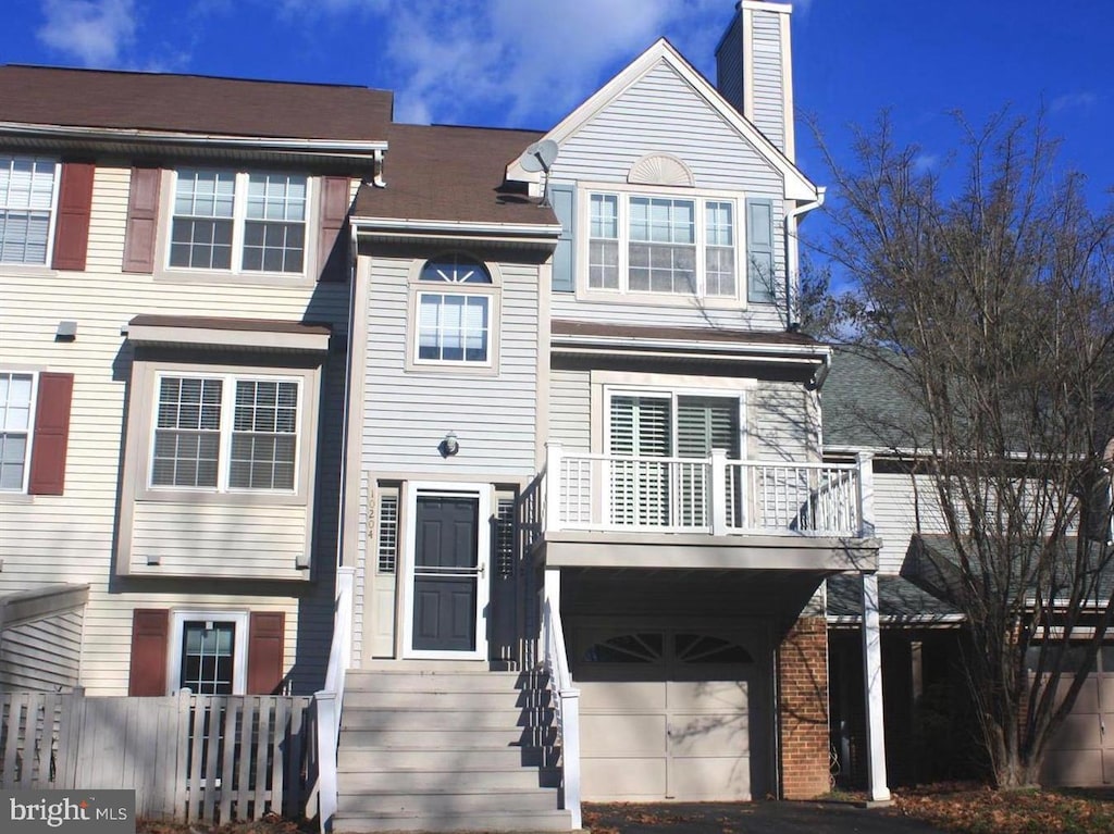 townhome / multi-family property featuring a garage and a chimney