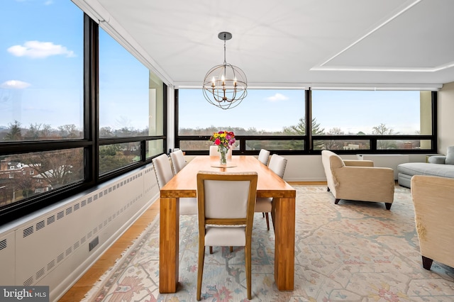 sunroom / solarium with radiator and an inviting chandelier