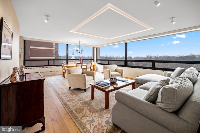 living room featuring plenty of natural light, a notable chandelier, and hardwood / wood-style floors