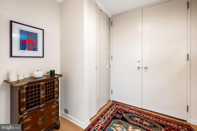 entrance foyer featuring light wood-type flooring and baseboards