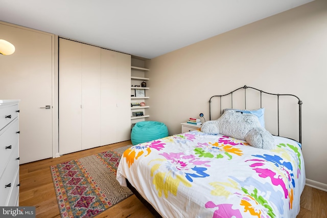 bedroom with light wood-type flooring and a closet