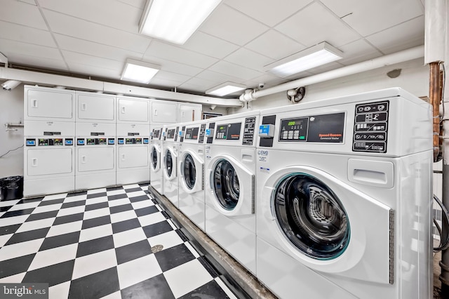 community laundry room with tile patterned floors, stacked washer and clothes dryer, and washer and clothes dryer