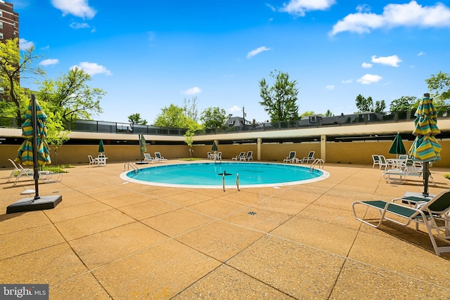 community pool featuring a patio and fence