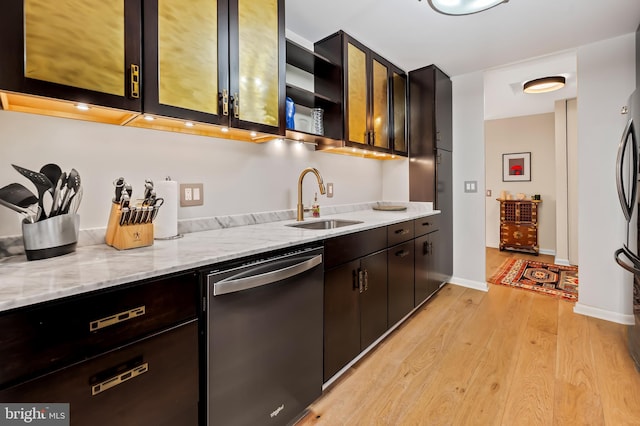 kitchen featuring open shelves, light wood-style flooring, a sink, dishwasher, and stainless steel dishwasher