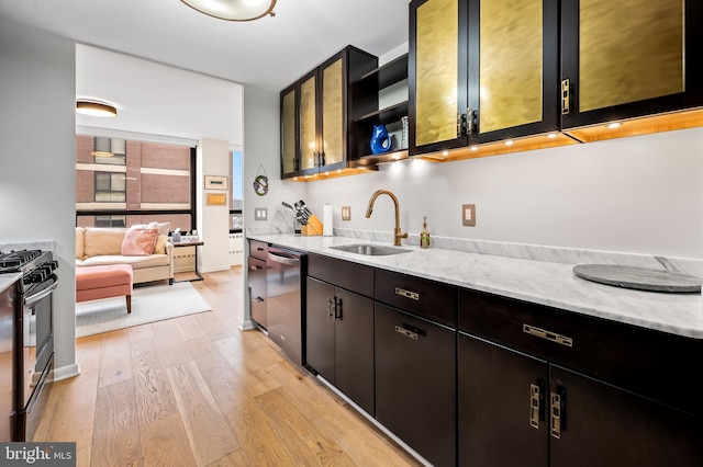 kitchen with a sink, light wood-type flooring, light stone counters, stainless steel appliances, and open shelves