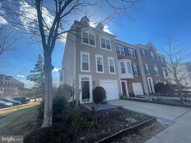 townhome / multi-family property featuring a garage, a chimney, and driveway