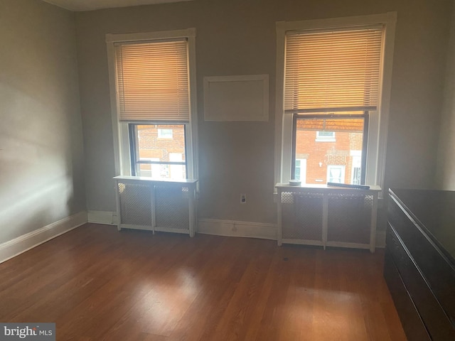 empty room featuring wood finished floors and baseboards