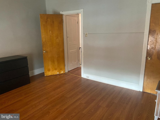 unfurnished bedroom with wood finished floors and baseboards