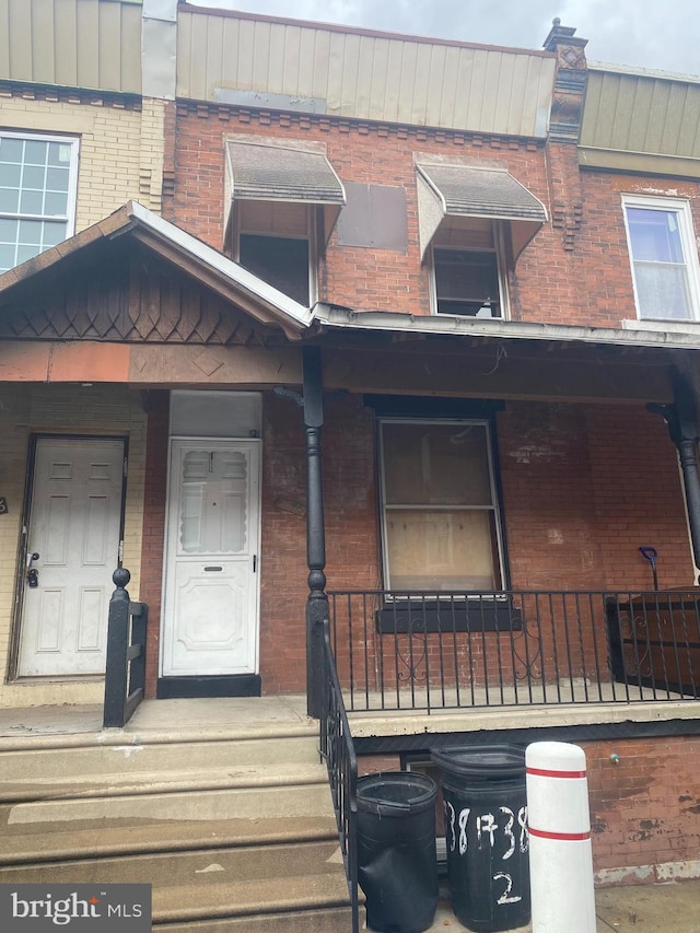 view of front of property with covered porch and brick siding