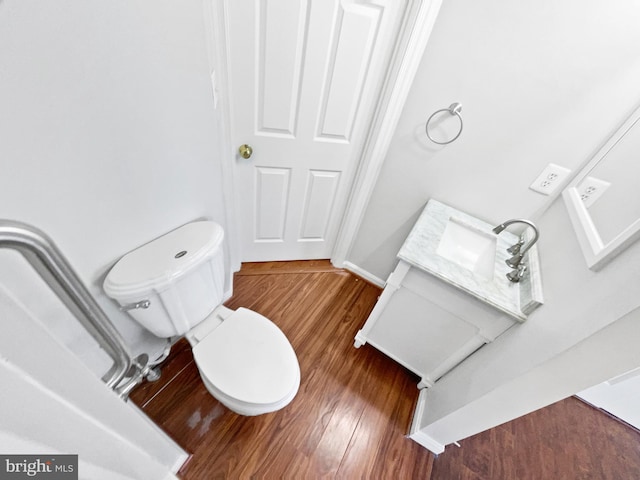 bathroom with wood finished floors, toilet, and baseboards