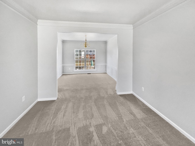 spare room with baseboards, carpet, ornamental molding, and a notable chandelier