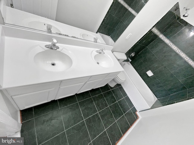 full bath with double vanity, tile patterned flooring, and a sink