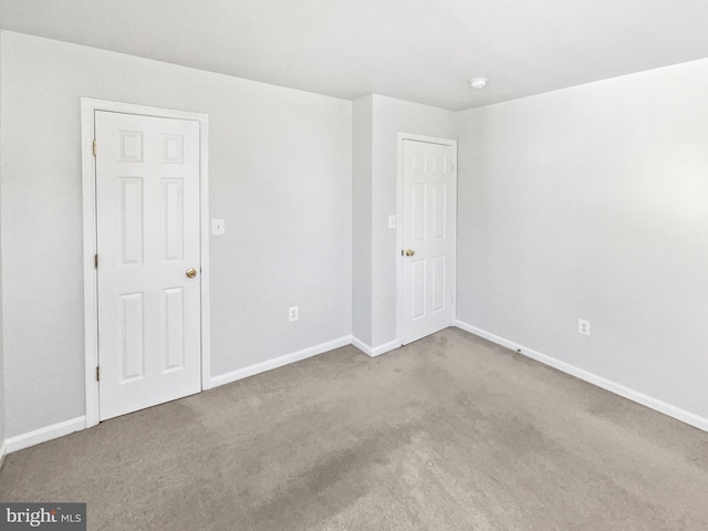 carpeted empty room with baseboards