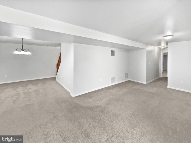 finished below grade area with stairway, carpet flooring, visible vents, and baseboards