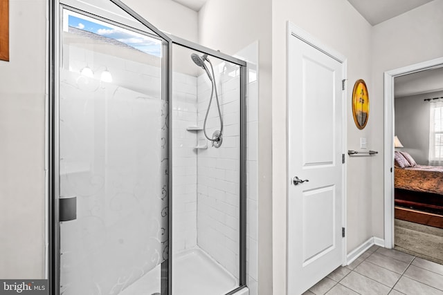 ensuite bathroom featuring ensuite bathroom, a stall shower, baseboards, and tile patterned floors