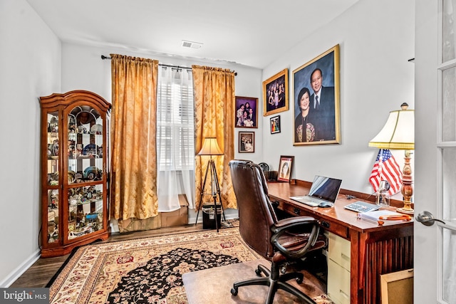 office featuring baseboards, visible vents, and wood finished floors