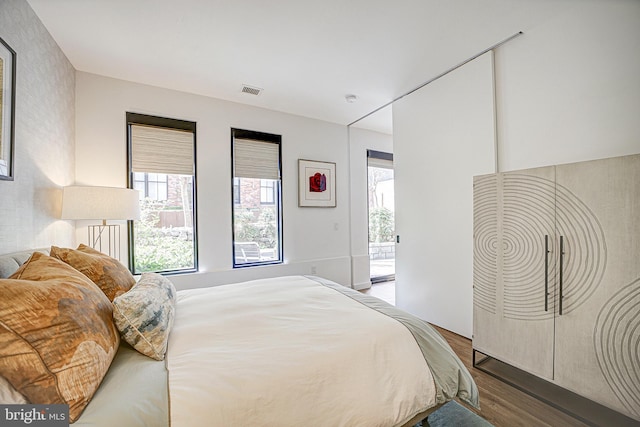 bedroom with wood finished floors and visible vents