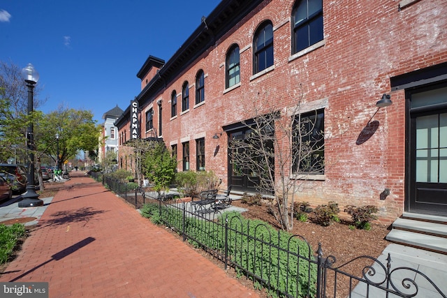 view of property featuring entry steps and fence