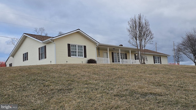 ranch-style home with a porch and a front lawn